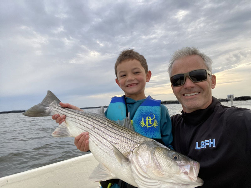 anglers with a rockfish in the chesapeake bay