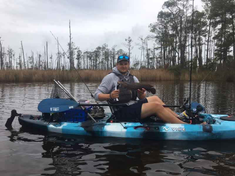 kayak angler catching a snakehead fish